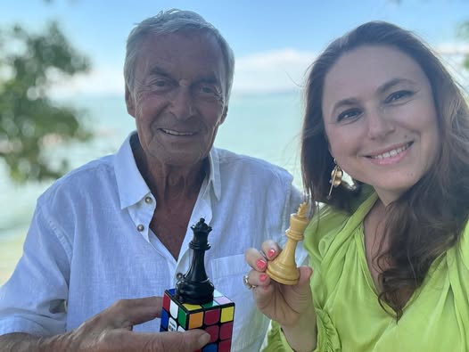 Эрнё Рубик (Ernő Rubik, слева) и венгерская шахматистка Юдит Полгар (Judit Polgár) с 2025 года пытаются «скрестить» Кубик Рубика (Rubik’s Cube) и шахматы, проводя одновременные соревнования по разрешению головоломки Кубик Рубика и игре в шахматы.